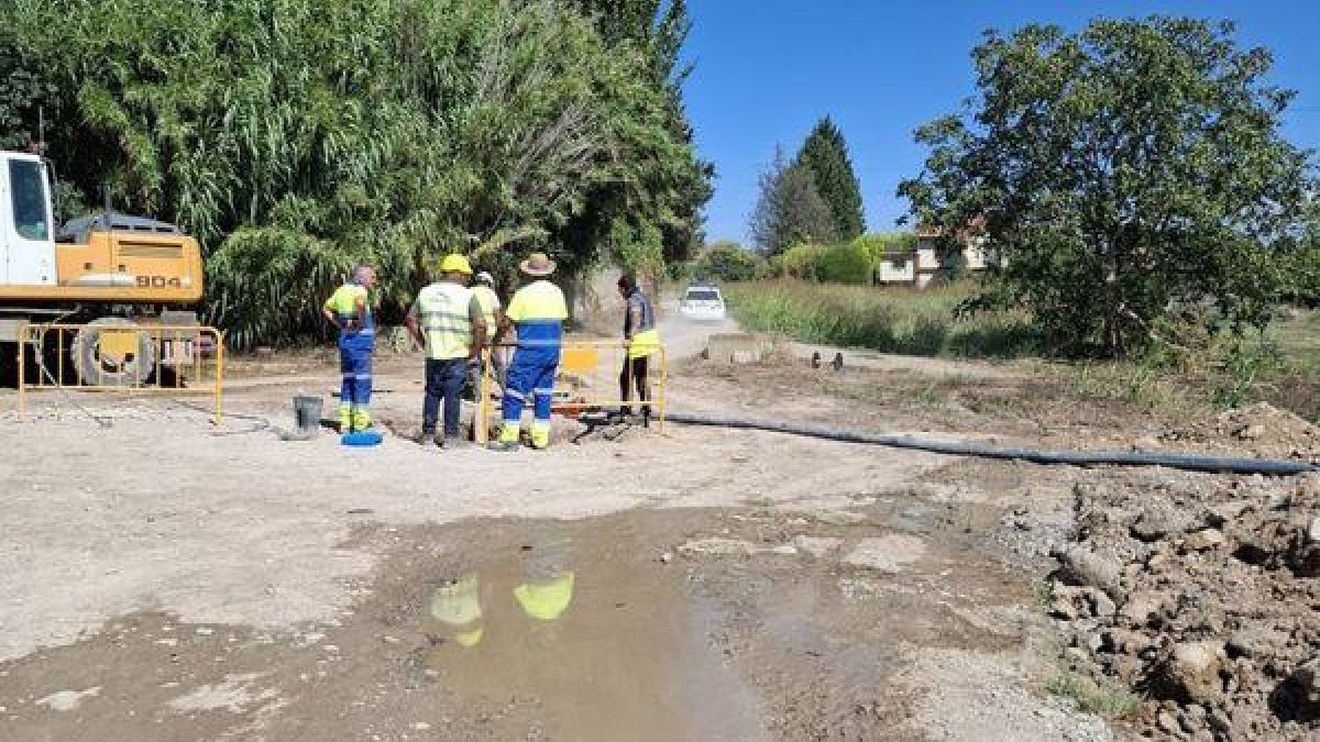 Operarios junto a la zona del reventón de la tubería, y el agujero lleno de agua. - AAVV HORTA SUD