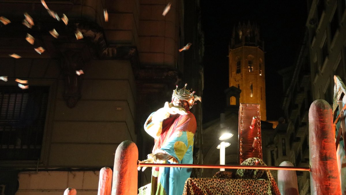 El rei Baltasar tira caramels durant la cavalcada de Lleida amb la Seu Vella al fons.
