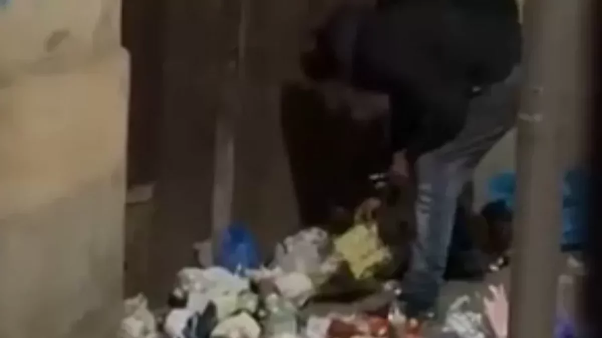 Un home escampant escombraries d’una bossa per la vorera.