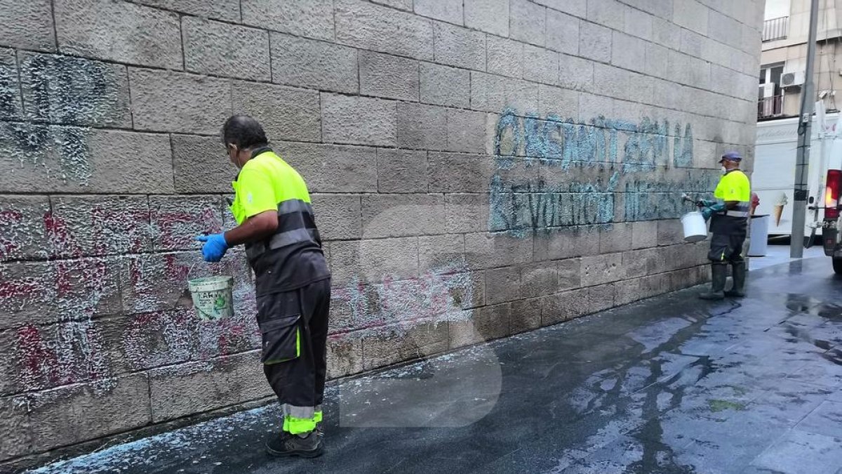 Operarios limpiando la pintada que apareció a la fachada del IEI y donde finalmente hubo que aplicar técnicas especiales para suprimirla de esta joya del gótico civil.