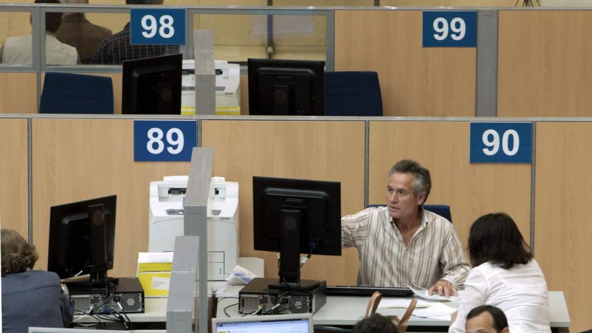 Imagen de una oficina de la Agencia Tributaria con personal atendiendo a contribuyentes.