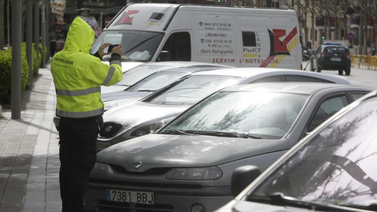 Imatge d’arxiu d’un vigilant de zona blava registrant fotogràficament una infracció.