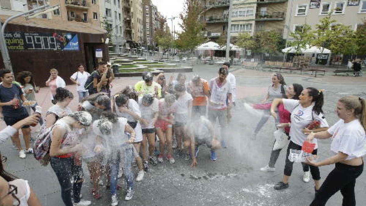 Estudiants nous d’Infermeria, ‘arrebossats’ amb aigua i farina a la Zona Alta.