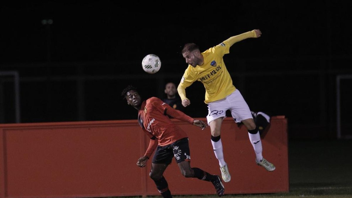 El delantero mallorquín del Lleida, Martí, salta por un balón ante la oposición de un jugador del Mallorca B.