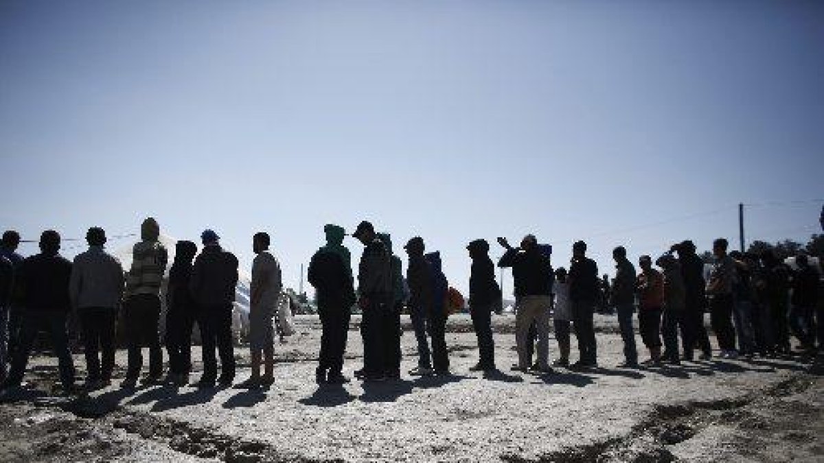 Refugiats fan cua per rebre aliments a Idomeni, Grècia.
