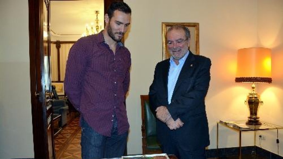 Saül Craviotto i Joan Reñé, ahir a la Diputació, observen les quatre medalles que atresora el palista.