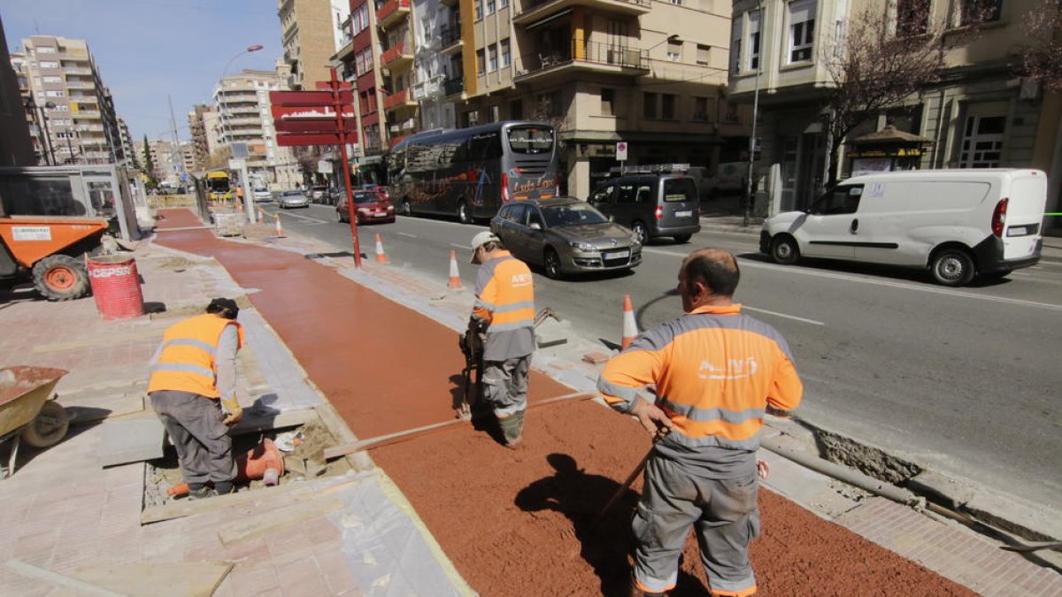Tres operarios trabajando ayer en la colocación del pavimento del carril para bicicletas.