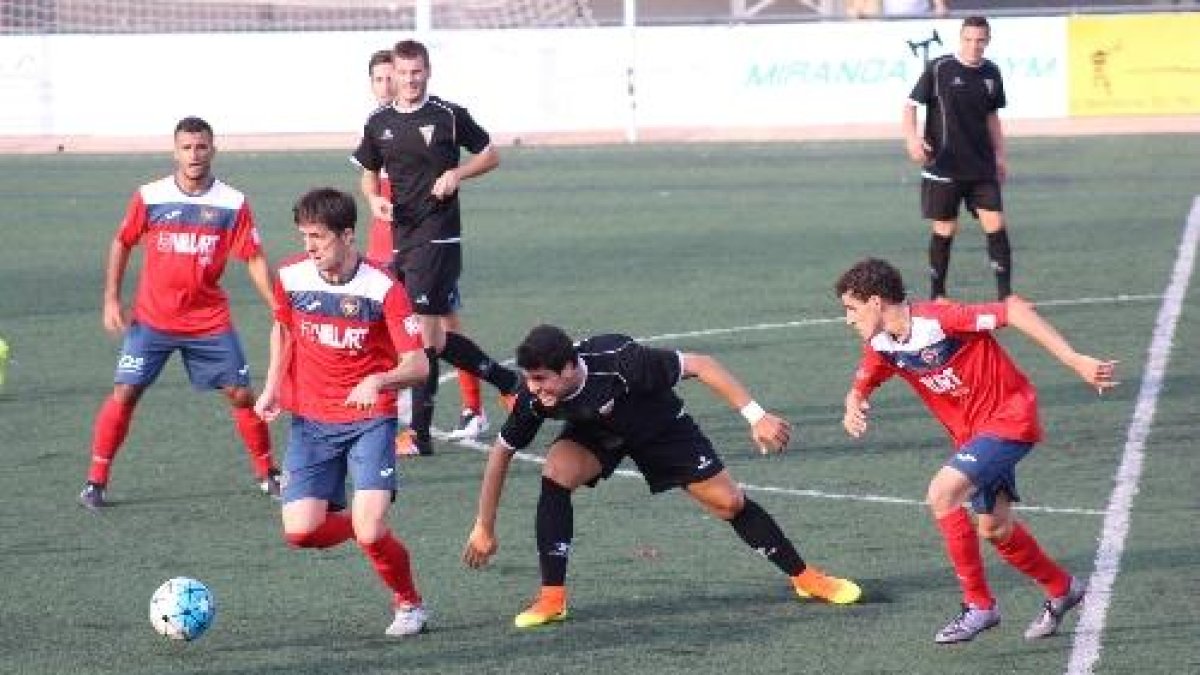 Asier Eizaguirre intenta controlar una pilota davant de la presència d’un rival i amb el seu company Galceran observant l’acció.