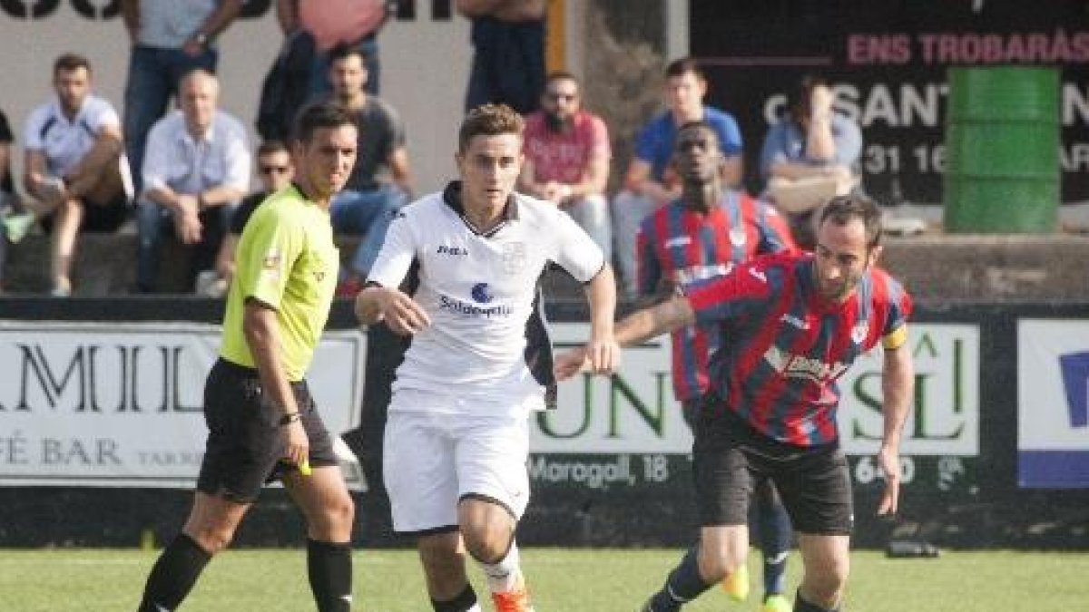 Un jugador del Borges controla l’esfèrica davant de la mirada de l’àrbitre i dos jugadors del Tàrrega.