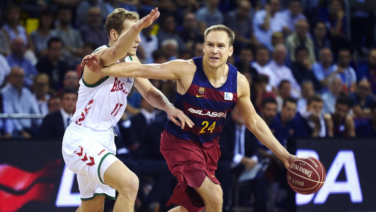 Brad Oleson porta la pilota davant de la pressió de Jaka Blazic.