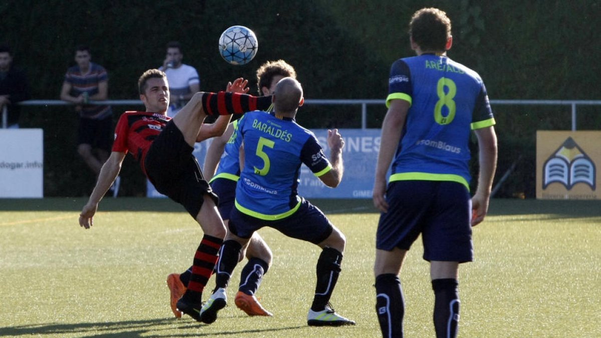 Un jugador de l’EFAC intenta controlar la pilota davant la pressió de dos futbolistes de l’Igualada.