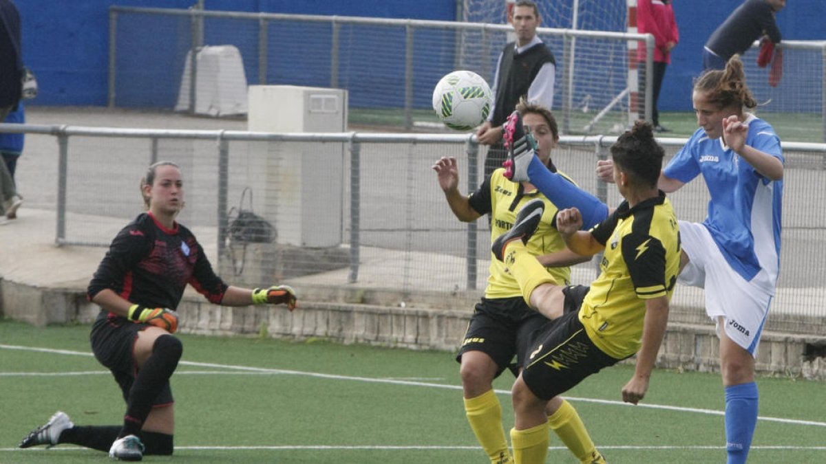 Una jugadora de l’AEM intenta rebutjar una pilota entre dos rivals.