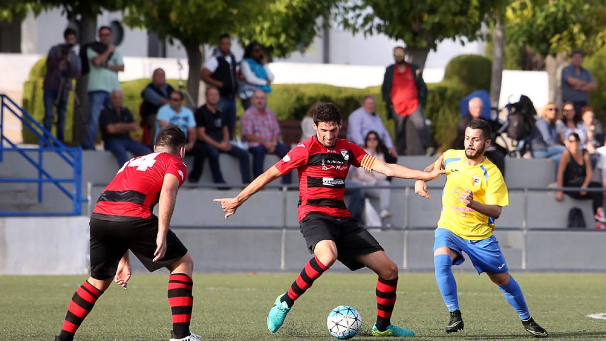 El capità de l’EFAC Almacelles es disposa a passar la pilota davant de la pressió d’un contrari.
