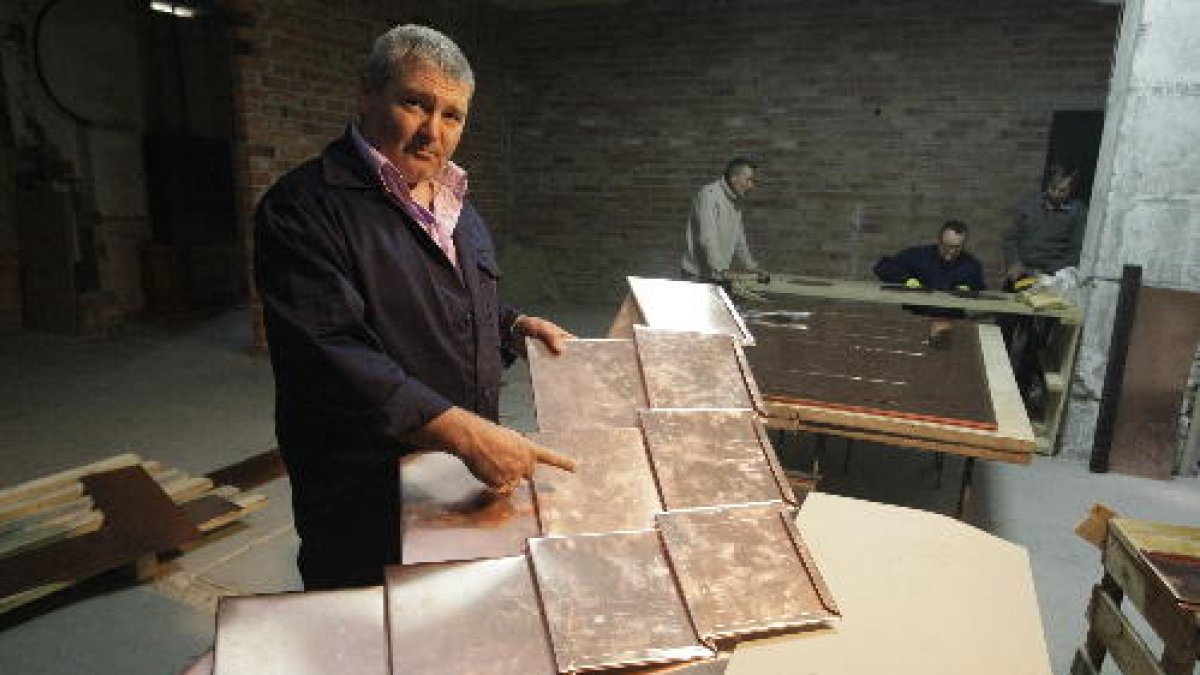 Un voluntari mostra com quedaran les llosetes de coure a les cúpules.