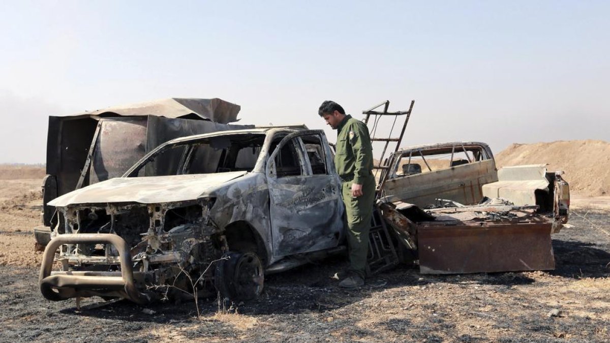 Un soldat de les forces kurdes peixmergues observa les restes d’un vehicle a prop de Mossul.