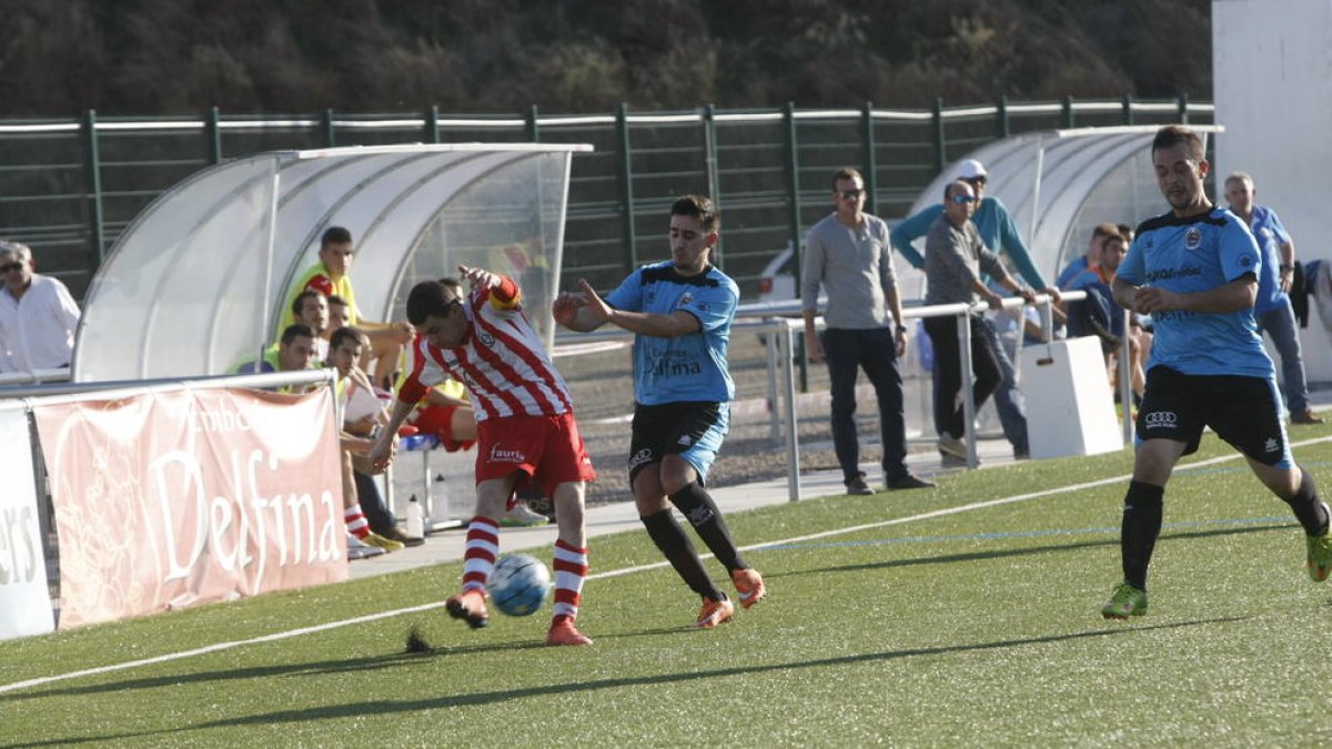 Un jugador de l’Athletic Almacelles intenta rebutjar una pilota des de la banda.