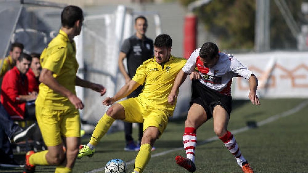 Un jugador de l’EFAC intenta controlar la pilota davant de l’oposició d’un rival.
