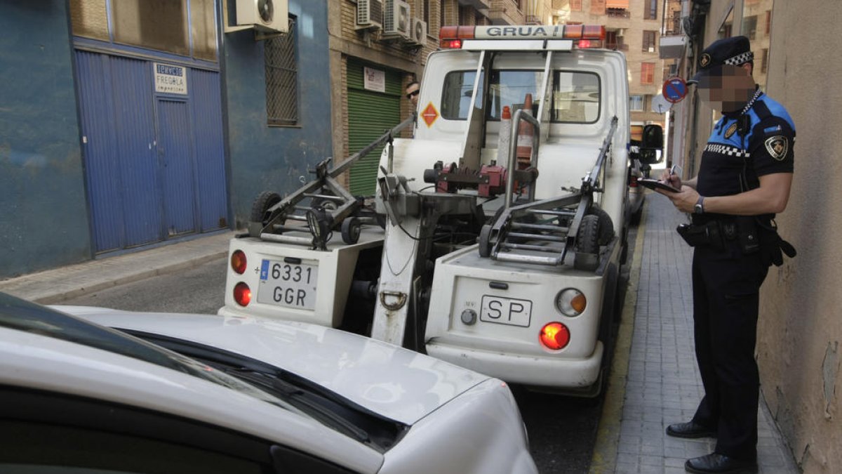 Imatge d’arxiu d’un agent retirant un vehicle amb la grua.