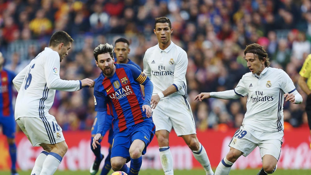 Leo Messi, que no va estar lluny de la seua millor versió, intenta controlar una pilota envoltat pels madridistes Kovacevic, Cristiano Ronaldo i Modric.