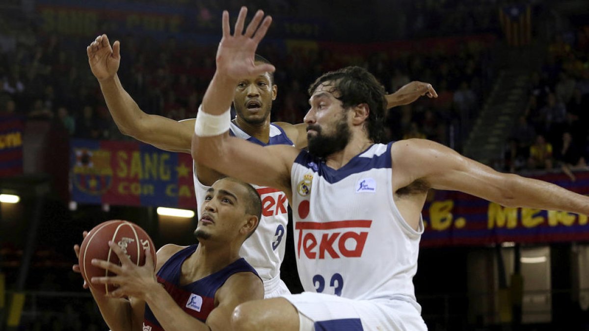 El blaugrana Stefan Peno intenta superar sota la cistella Sergio Llull i Anthony Randolph.
