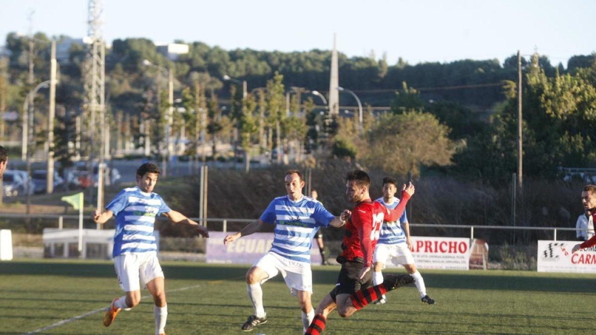Un jugador del EFAC dispara a puerta ante dos rivales en una jugada del partido.