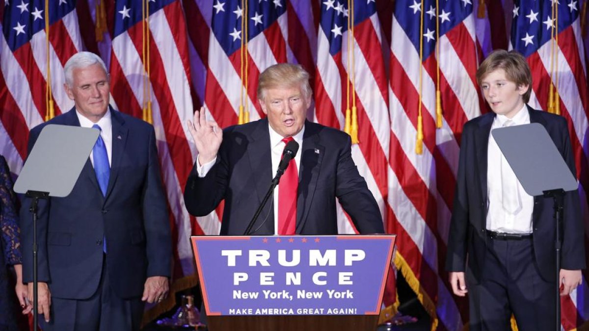 Donald Trump saluda a sus simpatizantes acompañado de su vicepresidente, Mike Pence  (izq), y de su hijo Barron.