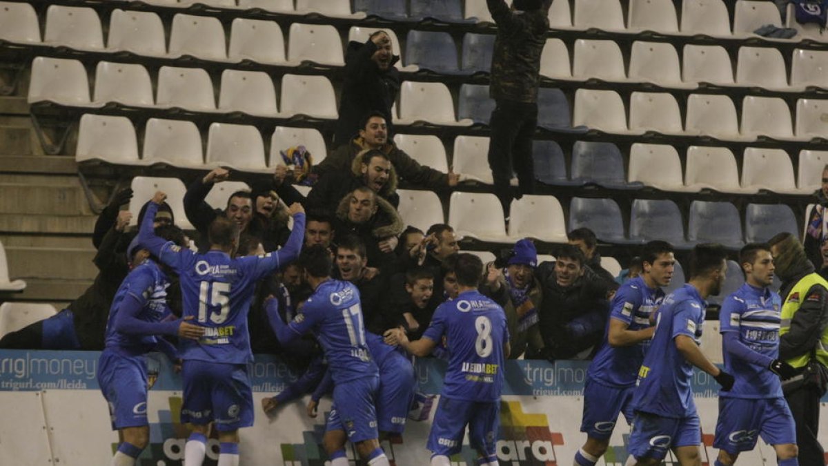 Jugadores del Lleida celebran con aficionados la victoria del pasado viernes sobre el Llagostera.