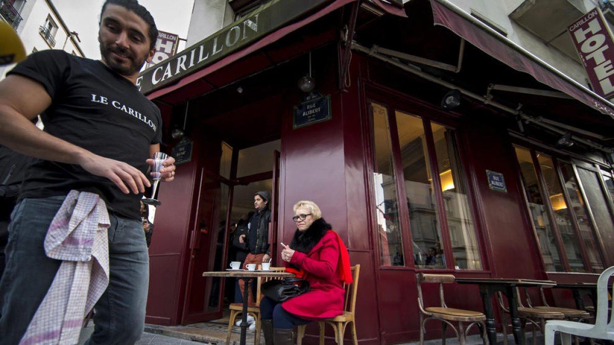 Una mujer toma café en la terraza de Le Carillon, uno de los locales atacados en París.