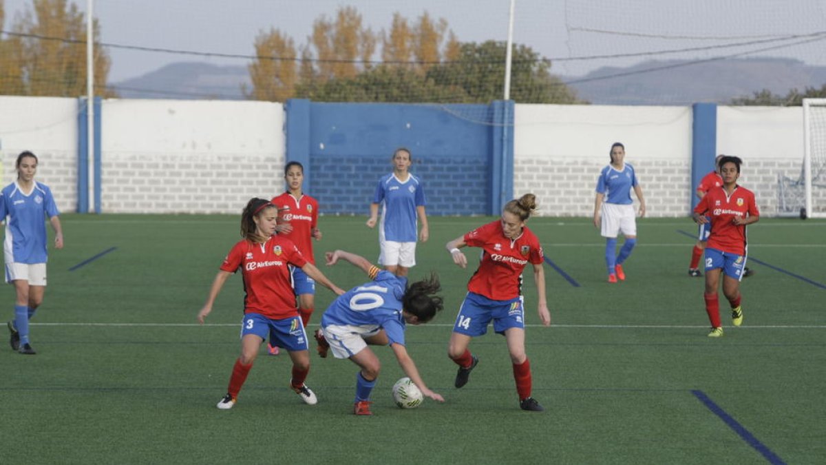 Una jugadora del AEM trata de controlar el balón ante la oposición de dos rivales.