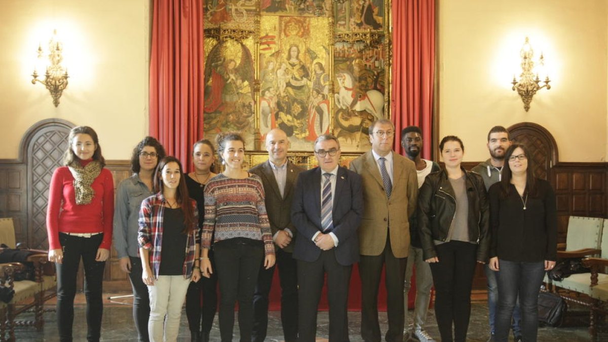 Foto de família dels joves que començaran avui a treballar a la Paeria, al costat de Ros, Peris i Salvia.