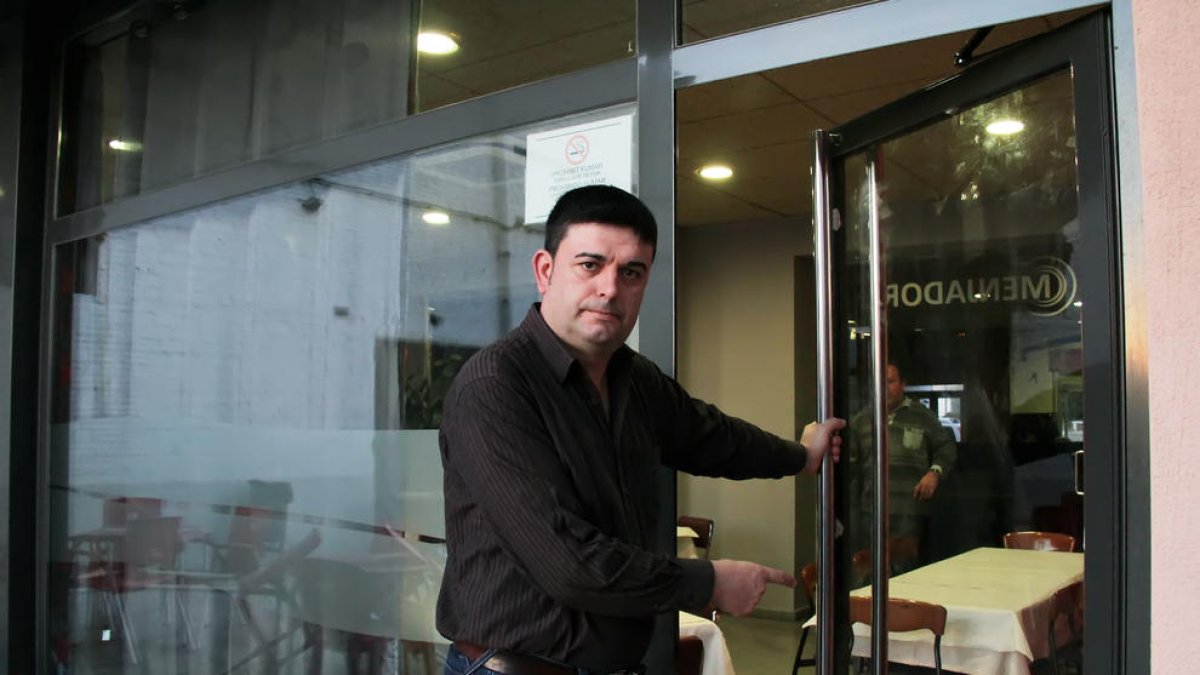 El propietari del bar mostrava ahir a la tarda la nova porta que li van col·locar després del robatori.