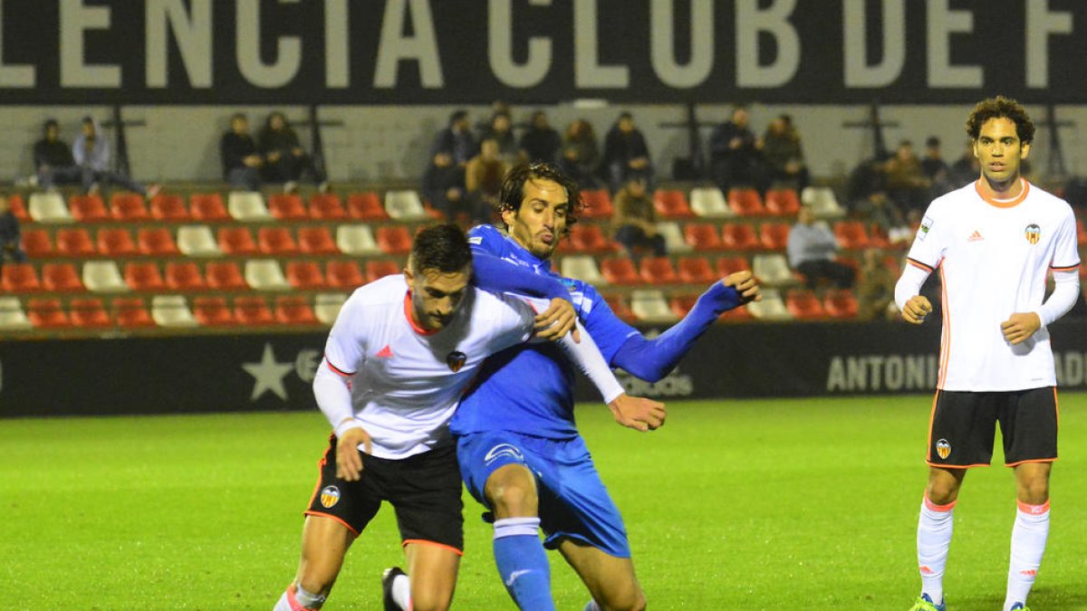 Fran Moreno, que estuvo desafortunado en la línea general del equipo, lucha por el balón con un defensa del Valencia Mestalla.