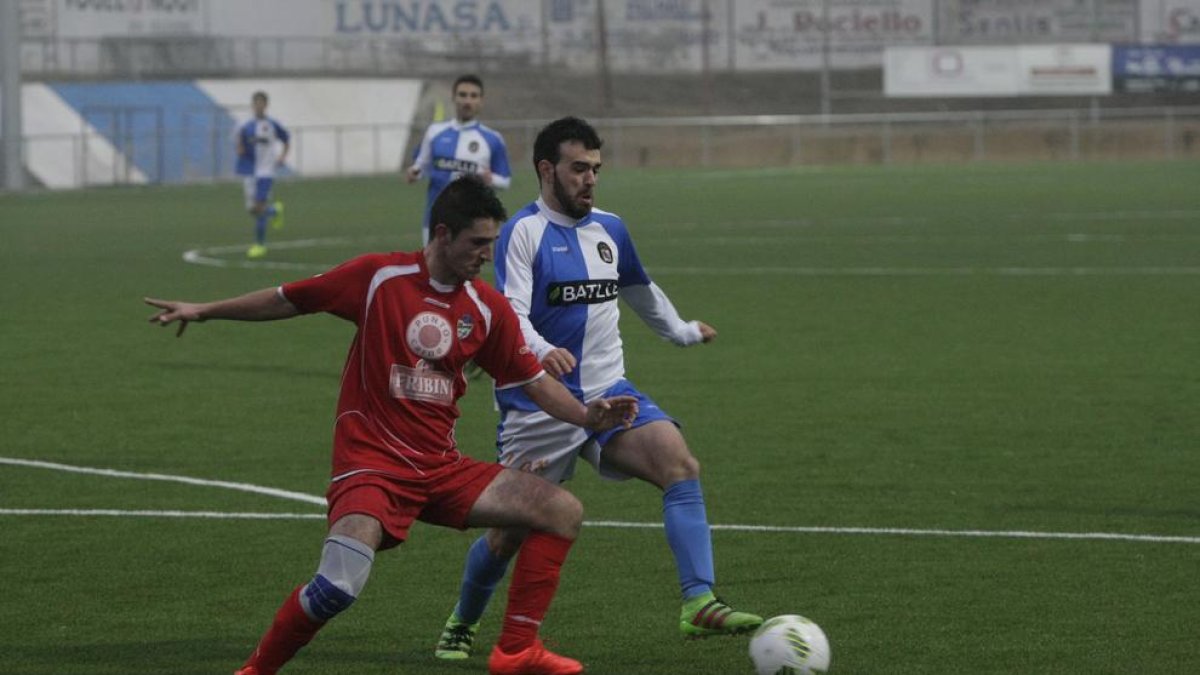 Un jugador del Tamarit i un del Binèfar disputen una pilota.