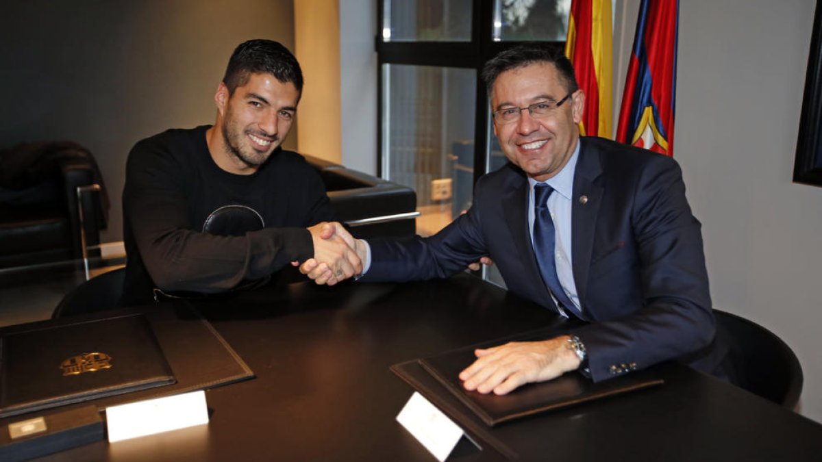 Luis Suárez junto al presidente Josep Maria Bartomeu, tras la firma de su renovación hasta 2021.