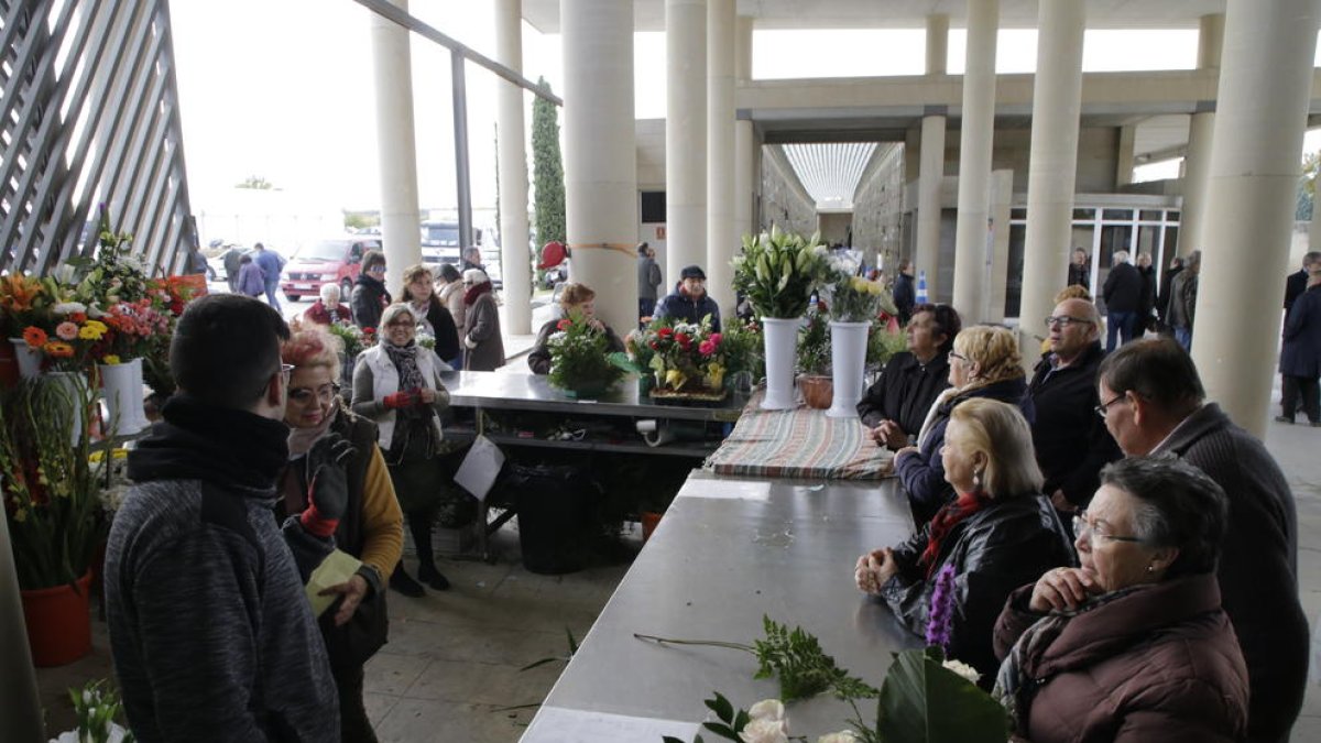 Desenes de persones compraven flors dimarts al cementiri de Lleida.