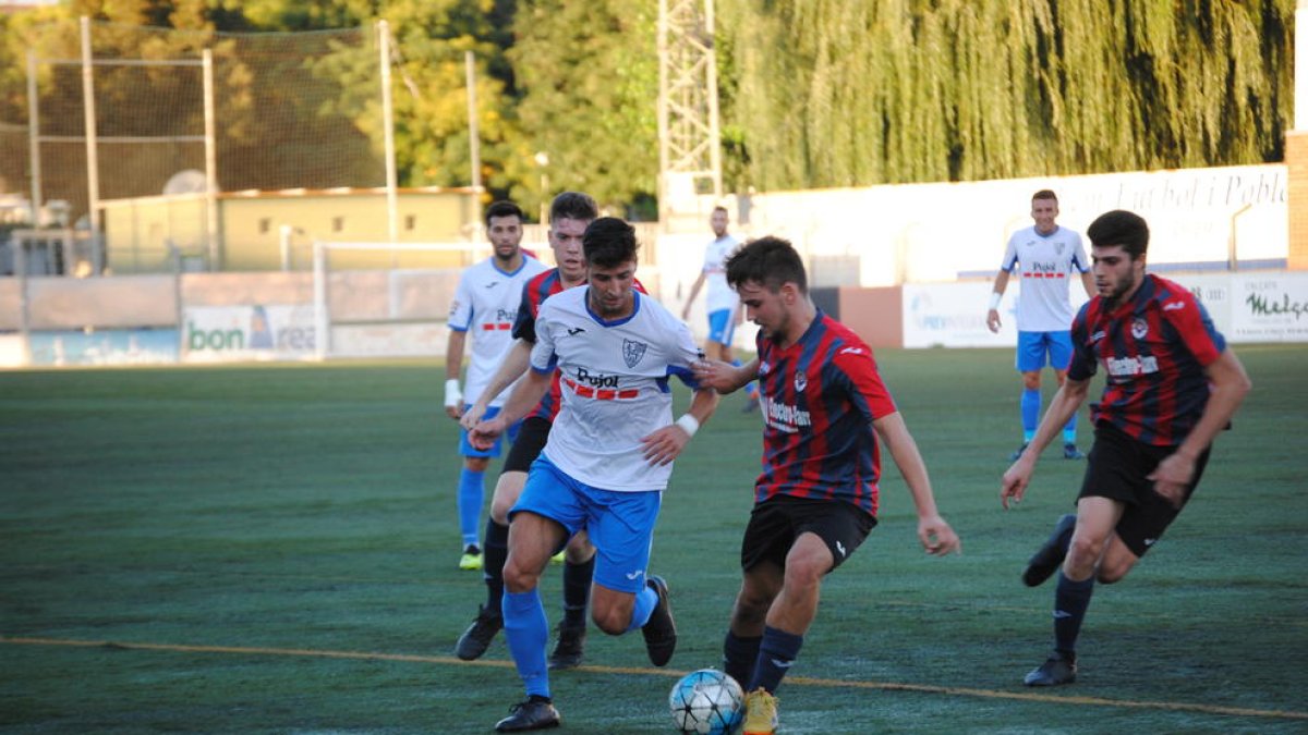 Una pugna entre dos futbolistes, ahir durant el partit al Municipal de Mollerussa.