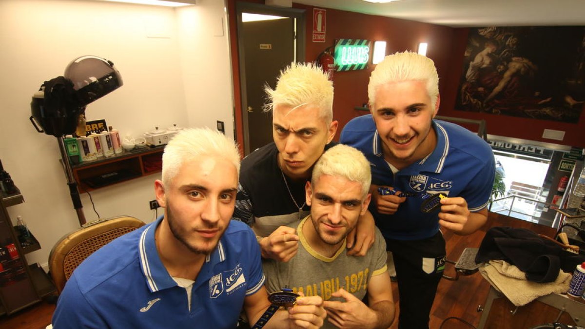 Roberto i Bruno di Benedetto, Darío Giménez i Albert Mola posen amb les medalles de campions al costat dels amos de Lluís Perruquers.
