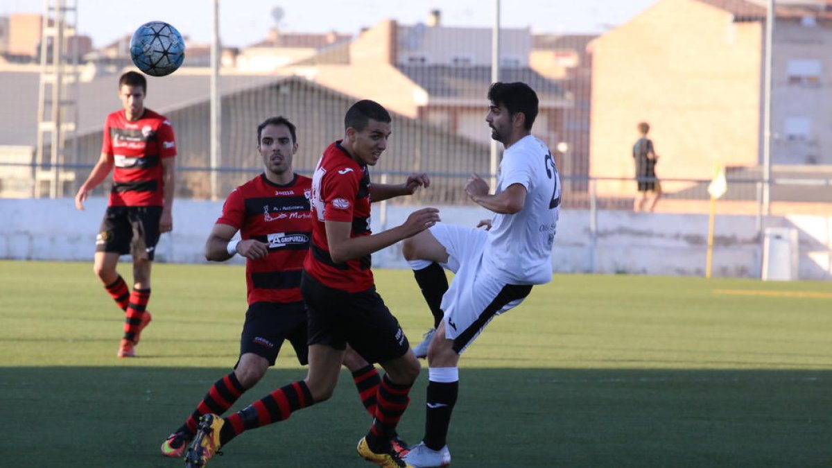 Jugadors dels dos conjunts pugnen per una pilota aèria.