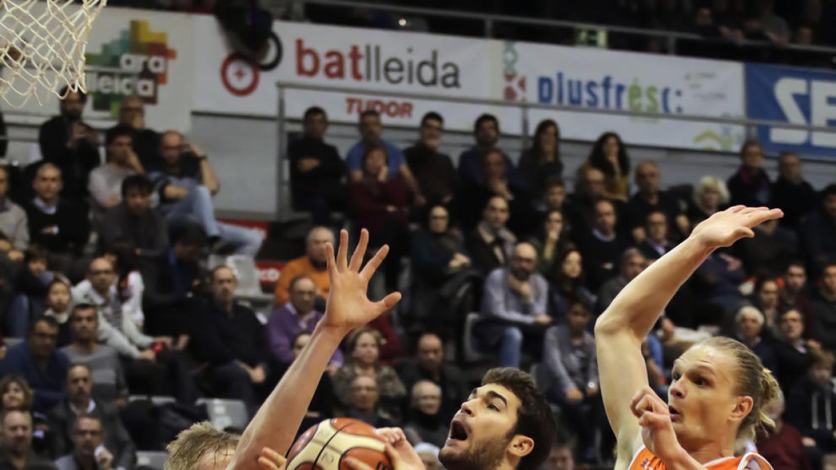 Gerard Sevillano entra a canasta defendido por Tautvydas Sabonis y Gediminas Zyle, jugadores del Coruña.