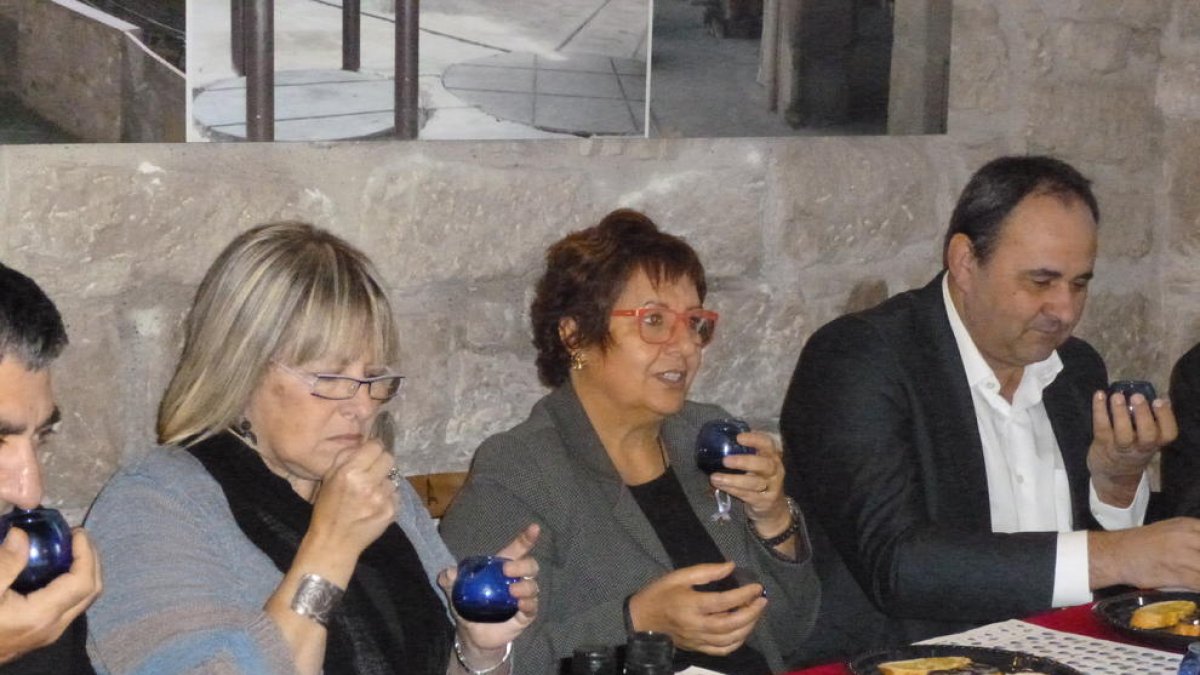 La consellera, al centre, degustant oli en la visita a Arbeca.