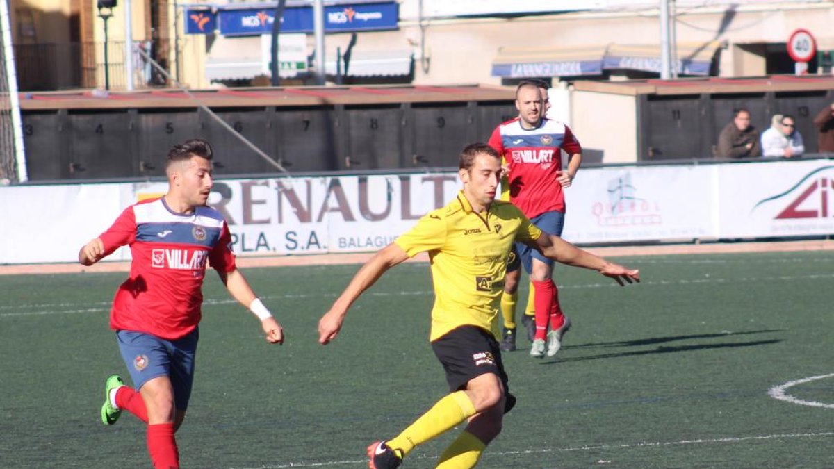 El local Genís persegueix un jugador de l’EFAC Almacelles, que juga la pilota a prop del centre del camp.