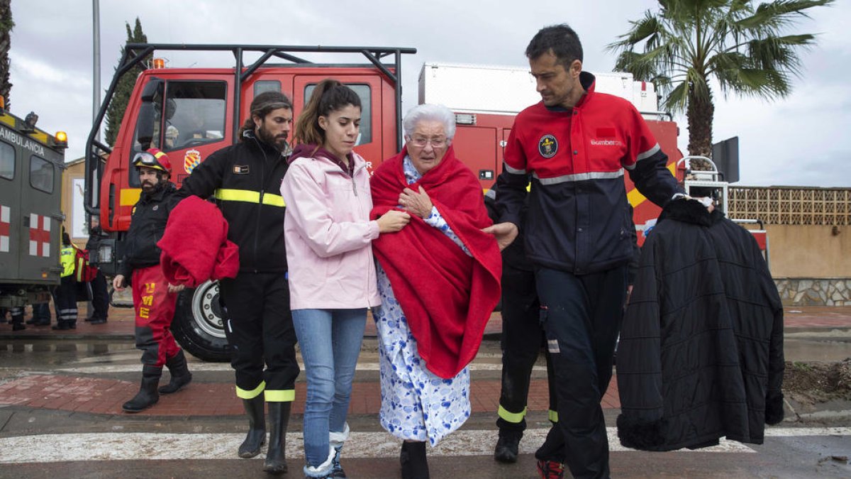 Diversos militars de la Unitat Militar d’Emergència (UME) traslladen una dona rescatada de la seua casa inundada a Los Alcázares, Múrcia.