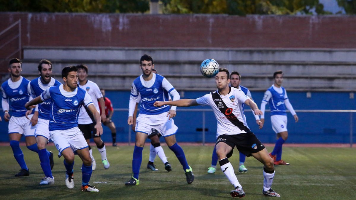 Un futbolista del Lleida B remata a portería ante la atenta mirada de varios jugadores del Morell.