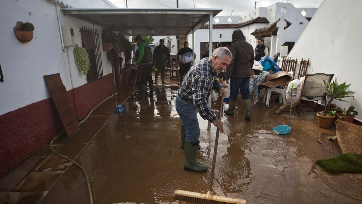 Veïns de Conil, a Cadis, buidant aigua i fang de les seues cases.