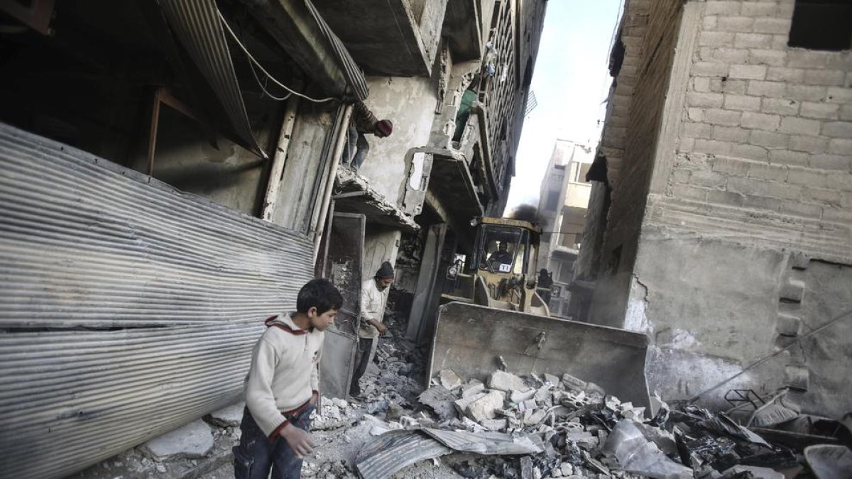 Diversos nens juguen entre les ruïnes causades pels bombardejos.