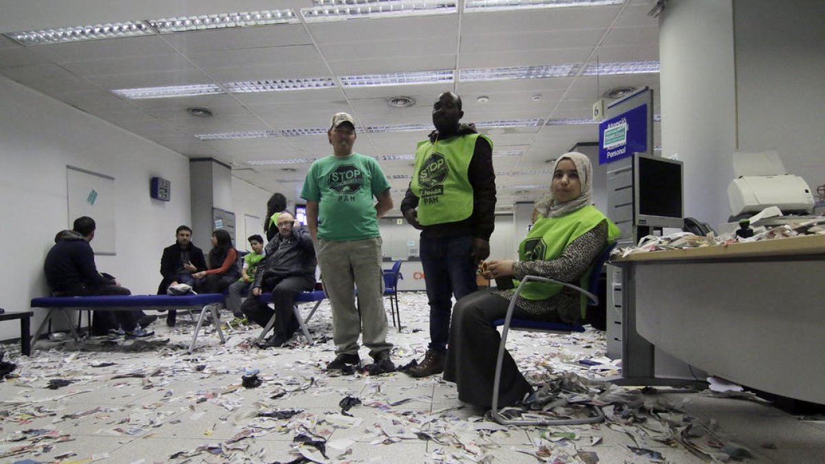 Membres de la PAH van okupar i van empaperar ahir al matí una oficina del BBVA de Ricard Viñes.