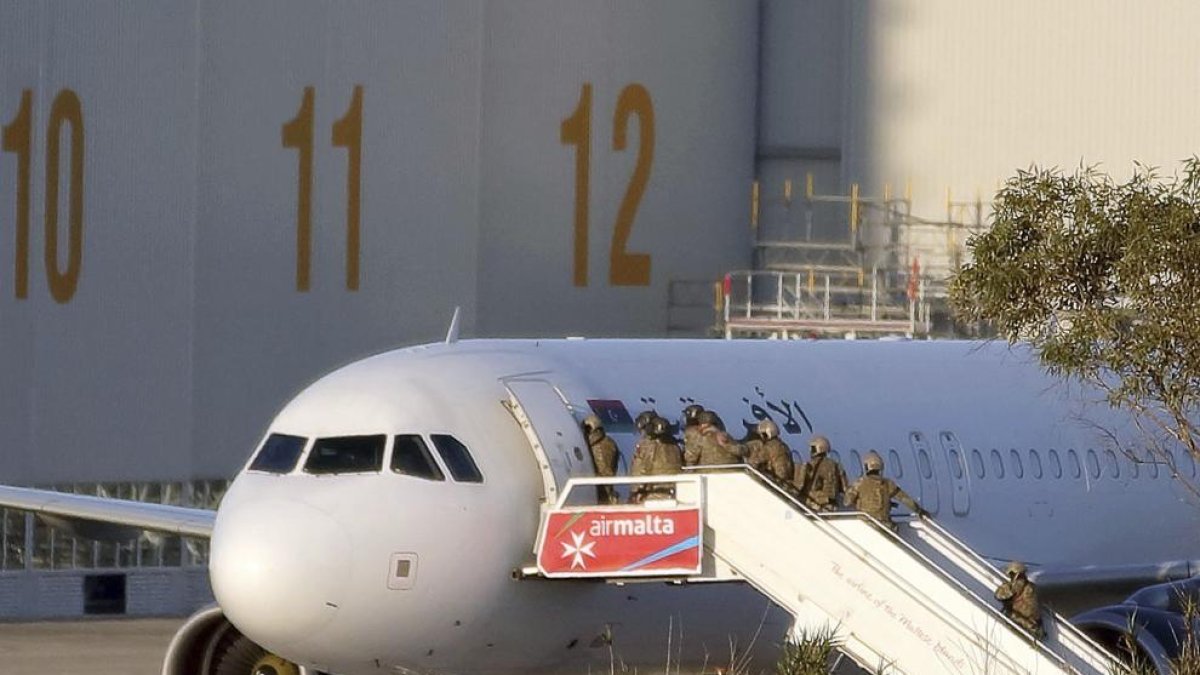 Miembros de las fuerzas especiales acceden al avión de Afriqiyah Airways secuestrado ayer.