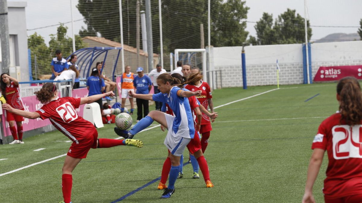 Una jugadora del AEM intenta controlar un balón ante la presión de una rival.