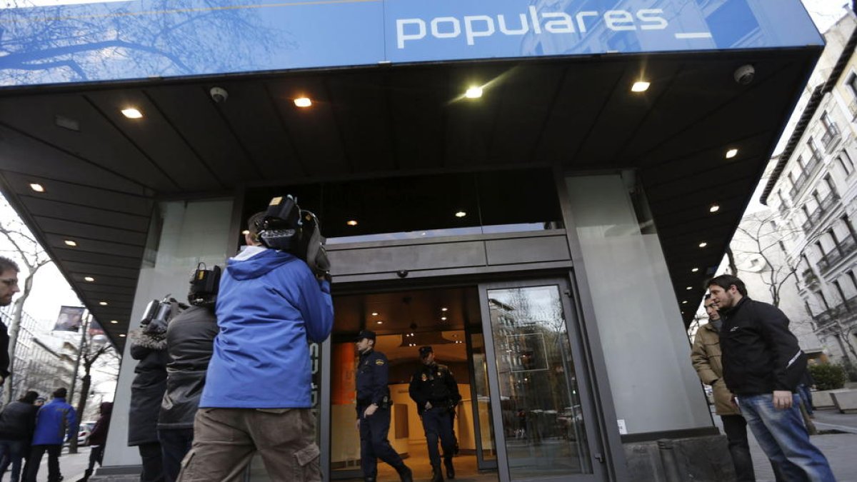 La Policía Nacional sale de la sede del PP en la calle Génova de Madrid, en una imagen de archivo.
