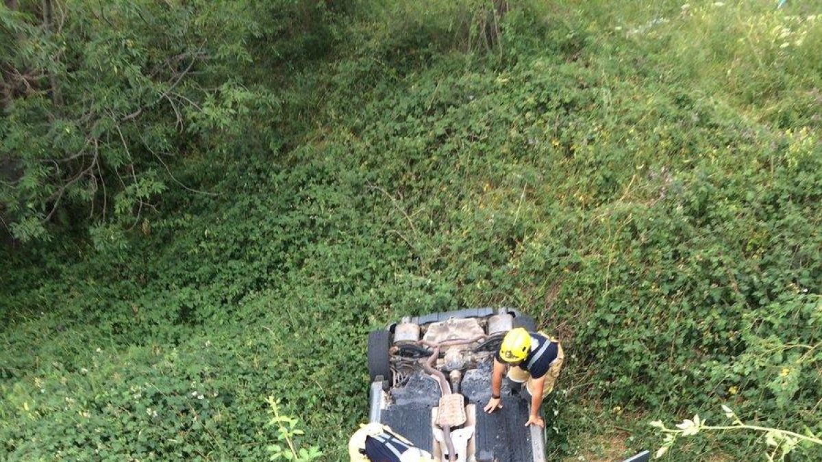 Bomberos auxilian al conductor tras volcar ayer en la L-501.